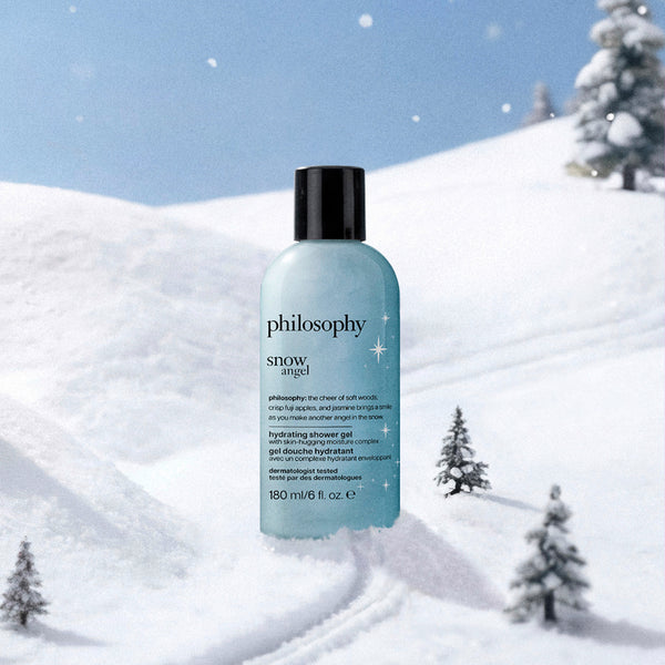 Philosophy Snow Angel hydrating shower gel in a light blue bottle with a black cap, set against a snowy winter landscape background.