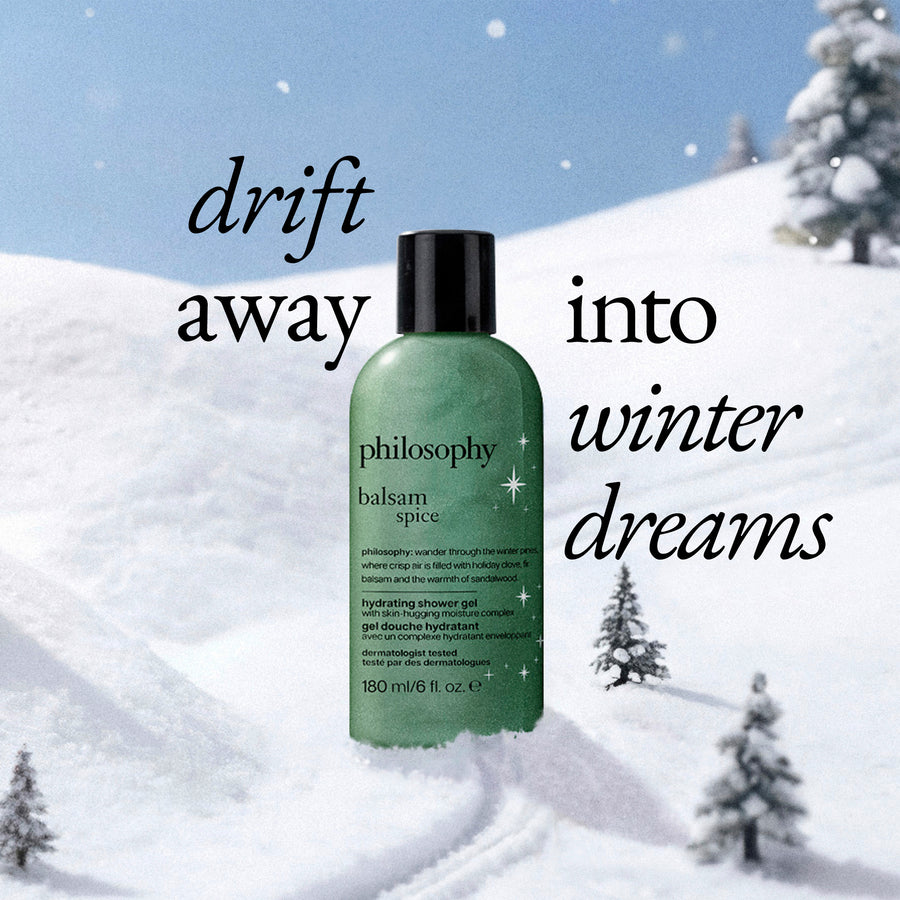 A bottle of Philosophy Balm Spice hydrating shower gel stands in a snowy winter landscape with text overlays reading 'drift away into winter dreams'. The product bottle is a translucent green with a black cap.