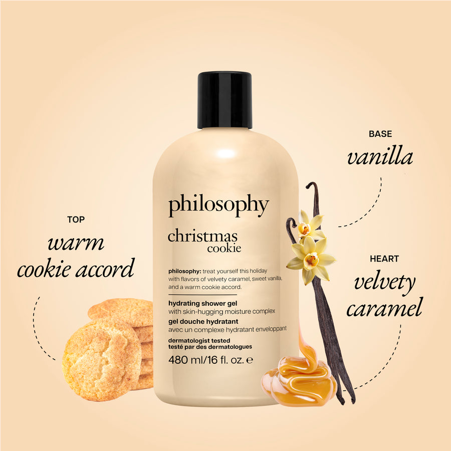 A bottle of philosophy Christmas Cookie hydrating shower gel centered on a warm beige background, with vanilla beans, cookie imagery, and text labels reading 'Base vanilla' and 'Heart velvet caramel' plus 'Top warm cookie accord'.