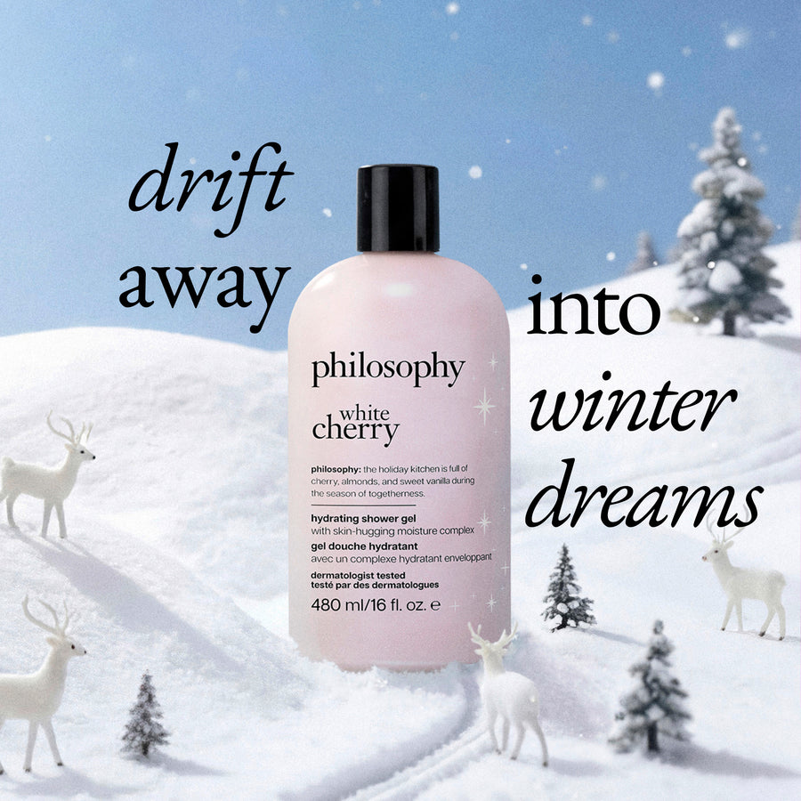 A bottle of Philosophy White Cherry hydrating shower gel stands in a snowy winter landscape with reindeer and trees. Large overlaid text reads 'drift away into winter dreams.